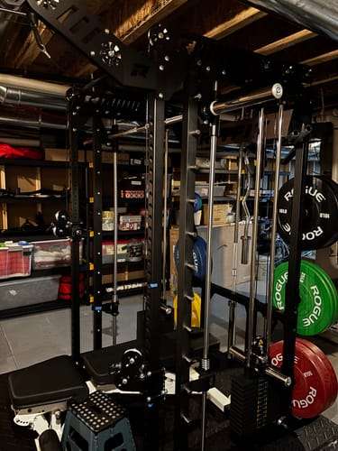 Customer's black RitFit M1 PRO Smith Machine fully assembled in a home gym with various weights attached.