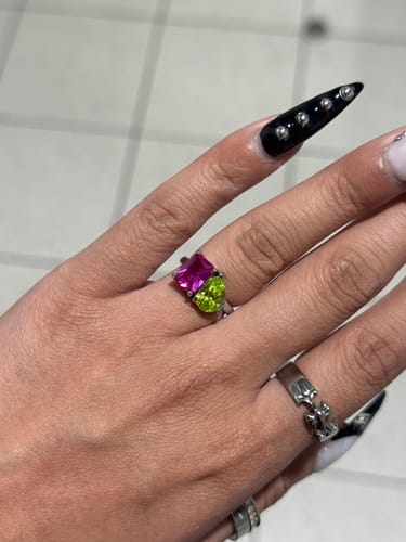 Close-up of a customer's hand wearing the Toi Et Moi Birthstone Ring with pink and light green stones.