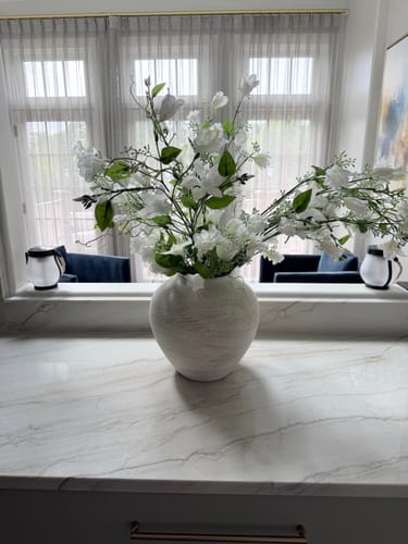 Reviewer's Faux Bell Flower & Clematis Arrangement in a textured white vase on a marble counter.
