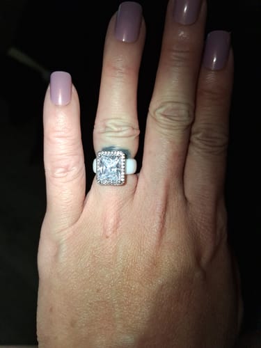 A reviewer's hand wearing the Rinfit Halo Silicone Ring, showing the white band and large, sparkling halo stone.