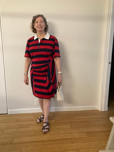 Customer provides a full view of the red and navy striped midi dress with a white collar and irregular hem.