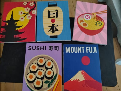 Kunde zeigt fünf fertig gemalte Mini-Leinwände aus dem 'Malen nach Zahlen'-Japan-Set.