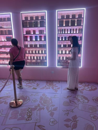 Reviewer and family inside the pink Walk Ins store looking at brightly lit makeup displays.