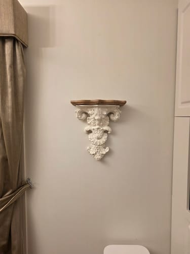 Customer's distressed white Elise Corbel Shelf with a timber top, mounted on a light-colored wall in their home.