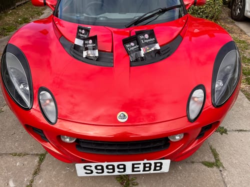 Customer's bags of English Style Liquorice Mix placed on the bonnet of a red sports car.