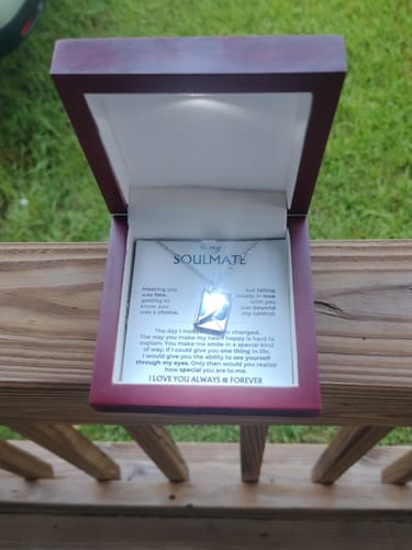 Customer's Love Letter Necklace in the mahogany gift box, illuminated by the built-in LED light.
