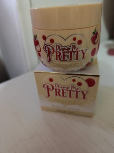 Customer's Plump Me Pretty Plumping Moisturiser jar, with cute apple illustrations, resting on its matching box.