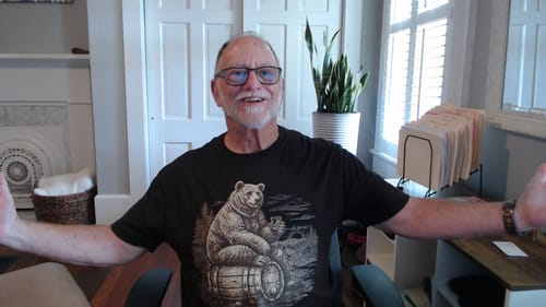 Customer smiling with arms outstretched, wearing the black Vintage Engraved Whiskey Bear T-Shirt.