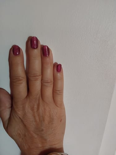 Kundenbewertung: Hand, die die beerentonigen, glitzernden „Galaxy Berry CatEye“ UV-Nagelfolien zeigt.