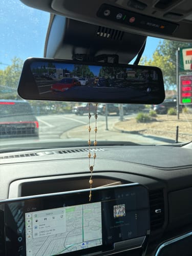 Customer's WOLFBOX mirror camera with the anti-glare film installed, showing a clear rear view on a sunny day.