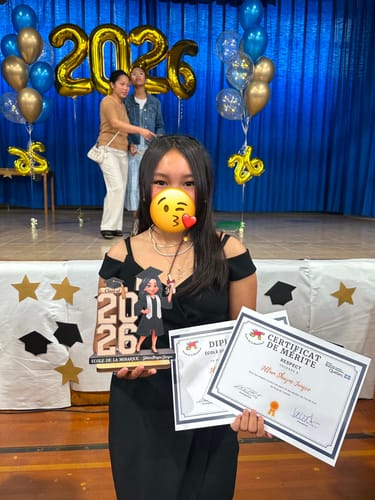 Reviewer holding the personalized wooden plaque and certificates at a graduation celebration.