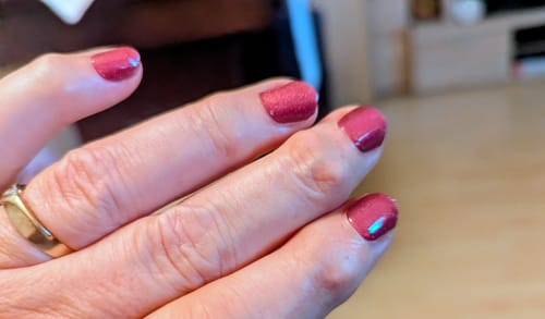 Rezensentin zeigt ihre Nägel mit den aufgetragenen „Galaxy Berry CatEye“ UV-Nagelfolien in einem schimmernden Beerenton.