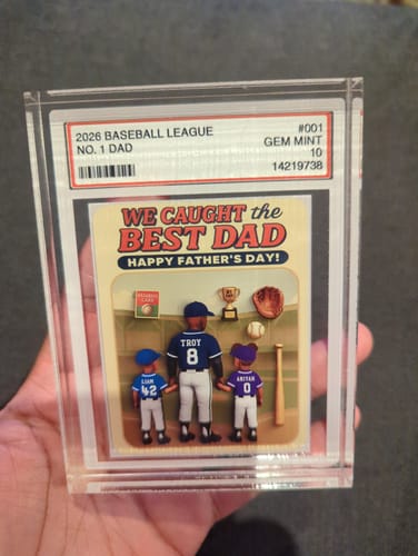 A reviewer holds up a personalized baseball card in a clear protective case, gifted for Father's Day.