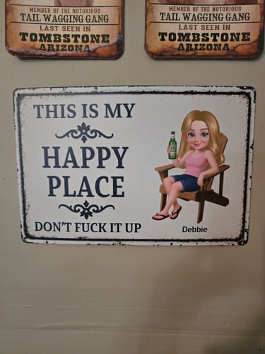 Customer's personalized metal sign on a wall, reading 'This Is My Happy Place Don't Fuck It Up' with a custom cartoon person.