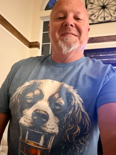 Reviewer wearing the blue Whiskey Dog Cavalier King Charles Spaniel T-Shirt, showing the fit.