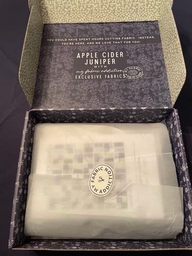 Customer's open box showing the Apple Cider Sew-Ready Quilt Kit wrapped neatly in tissue paper.