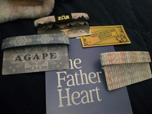 Customer's three Bible Club bracelets on their backing cards with the phrases Agape, Your Faithfulness, and Dearly Loved.