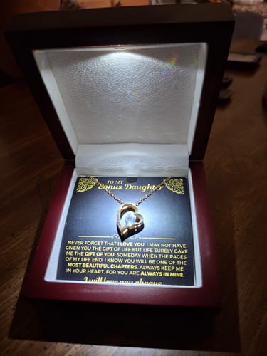 Customer displays the Forever Love Gift Set in its mahogany box, illuminated by a spotlight.