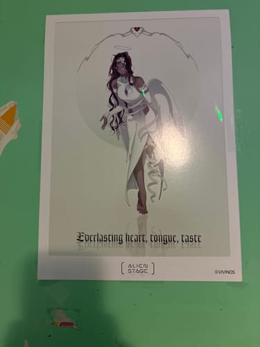 Customer's Alien Stage art print of the character Hyuna dressed as a white angel, shown on a table.