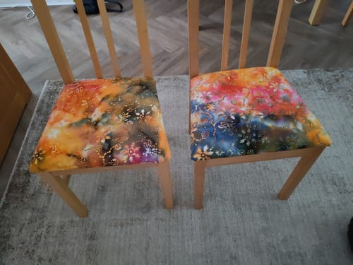 Customer's colorful Indian Cotton Batik fabric used to reupholster the seats of two wooden dining chairs.
