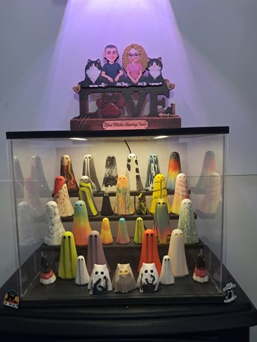 Customer's personalized 'You & Me And The Cat' wooden plaque displayed above a glass case of ghost figurines.