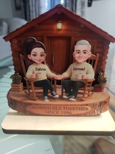 Customer's personalized wooden plaque showing a couple in rocking chairs with the names Sylvia and Ismael and text "Growing Old Together Since 1986".