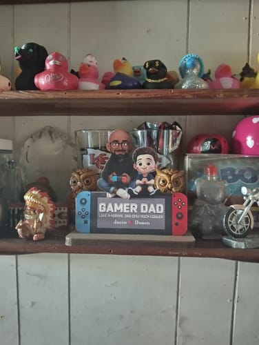 Customer's safely delivered 'Gamer Dad' gift plaque displayed front and center on a shelf.