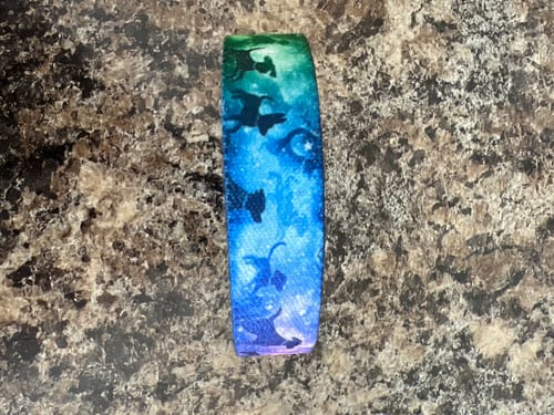 Customer's Until We Meet Again Dog Bracelet with a colorful galaxy design and dog silhouettes, shown on a countertop.