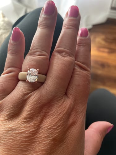 Reviewer's hand wearing the beige Silicone Ring with a large, oval-cut CZ stone.