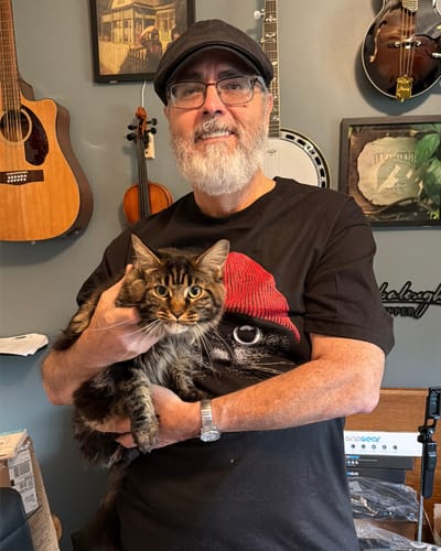 Customer wearing the black Statement Made - Tall t-shirt while holding a fluffy cat that resembles the shirt's graphic.