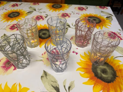 Recensore mostra sei tumbler in plastica con motivo geometrico, disposti su un tavolo.