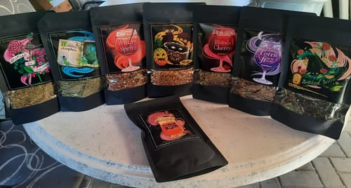Kunde zeigt das Cold Brew Tee Bundle mit sieben verschiedenen Sorten und dem Butterscotch Brew auf einem Tisch.