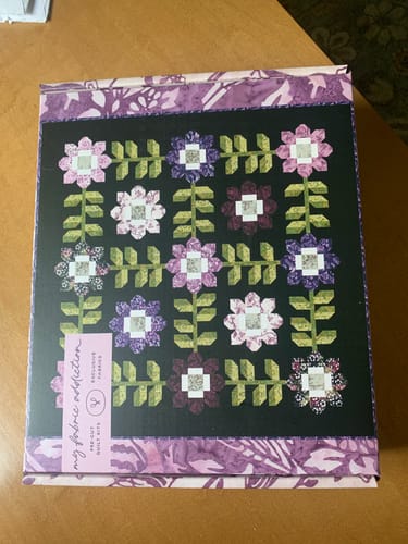 Reviewer's Edelweiss Quilt Kit box with the purple and green floral quilt design on the lid.