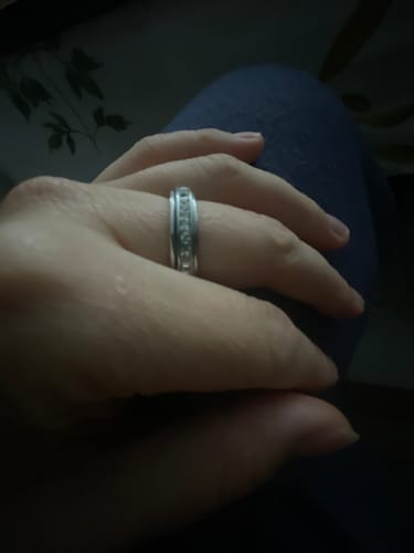 Kliento ranka iš arti, mūvinti Tylos žiedą „Calmy“.