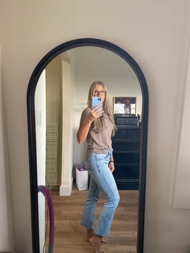 Reviewer taking a mirror selfie in the light wash Suki Luxe Stretch Kick Flare Jeans, showing the cropped length and fit.