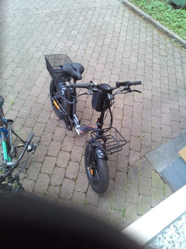 Customer's fully assembled black Vakole Y20 Pro e-bike with baskets, parked on a paved driveway.