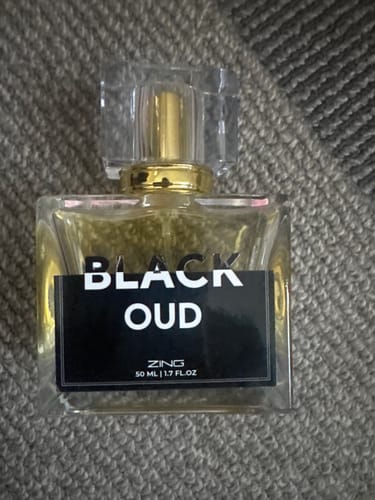 Customer's bottle of Black Oud from The Royal Oud Collection, resting on a gray textured fabric.