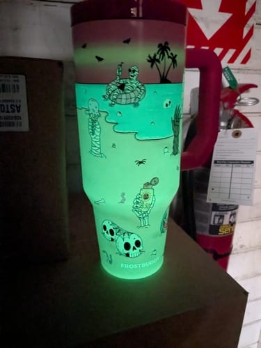 Customer's Sunscream Thicc Buddy 40oz mug with its skeleton design glowing a vibrant green in the dark.