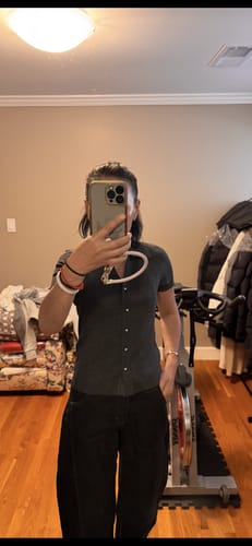 Reviewer takes a mirror selfie showing the fit of the dark, short-sleeve knitted cardigan.