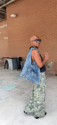 Reviewer standing outdoors, wearing the Denim Shoulder Bag to show its slouchy shape from the side.
