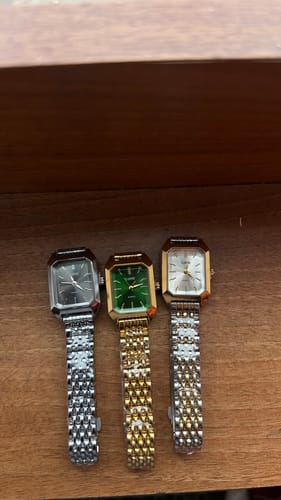 Reviewer shows three lovely CLAIRE DE MAINS watches: silver with a black dial, gold with a green dial, and two-tone with a white dial.