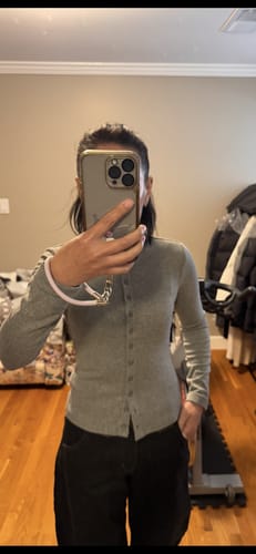 Customer wearing the grey cotton blend t-shirt fully buttoned, showing the slim fit from a front view in a room.