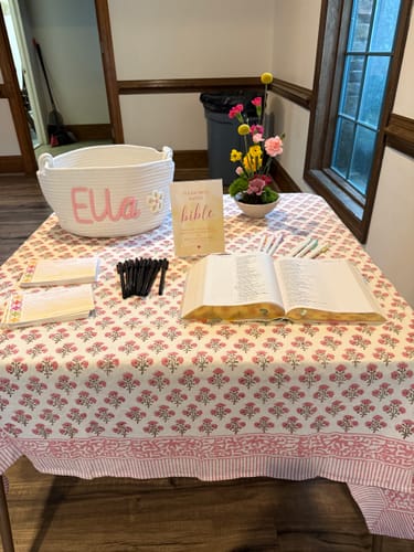 Customer's Personalized Knitted Basket with 'Ella' in pink yarn on a table at a baby shower.