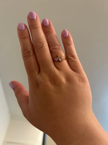 A customer wearing their Leesha Birthstone Ring on their finger, showing its two pear-cut stones on a gold band.