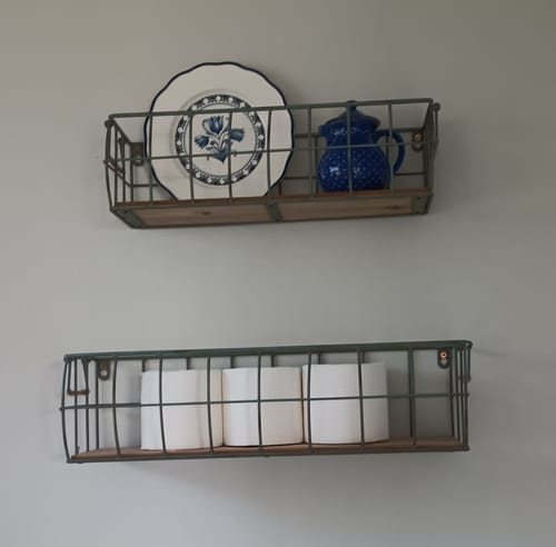 Reviewer's Aurelie wire baskets mounted in a bathroom, holding decorative items and toilet paper.