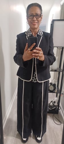 Reviewer wearing the black two-piece set with white piping, styled with a black blazer for a casual work outfit.