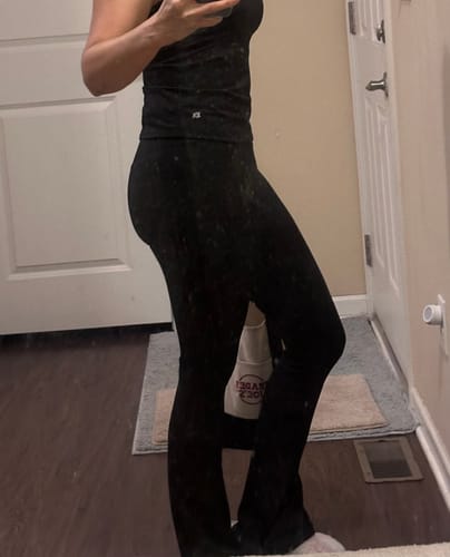 Reviewer showing a side view of the black Vital Flare Leggings, highlighting the snug fit.