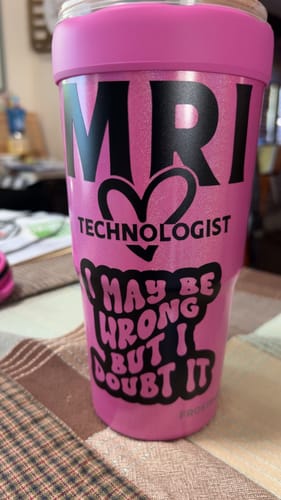 A customer's pink sparkly To-Go Buddy with custom black decals reading 'MRI Technologist' on a table.
