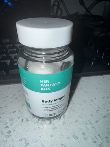 Customer's bottle of Body Magic Chlorophyll Pills, a clear jar with a white lid, sitting on a countertop.