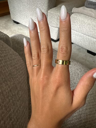 Customer's hand wearing the gold Eloise Birthstone Ring, showing the clover settings with inset birthstones.